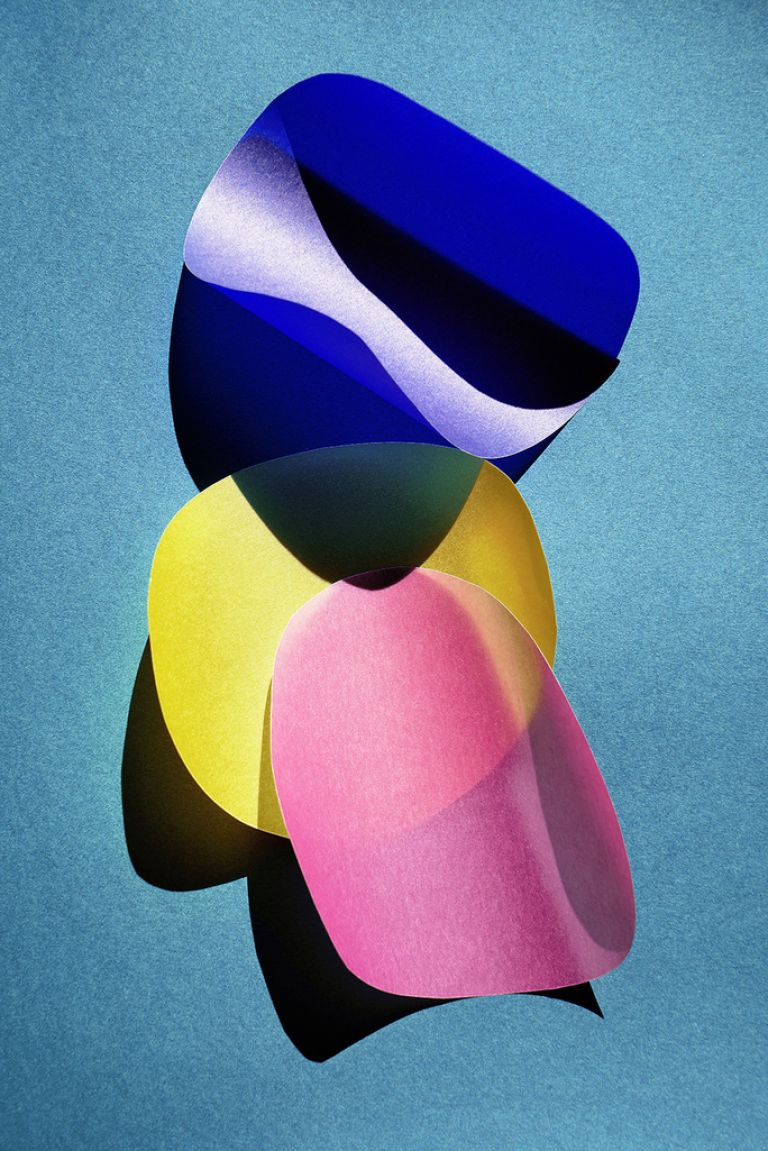 Ein blauer, ein gelber und ein rosa Kreis aus leicht gewelltem Transparentpapier liegen &uuml;berlappend auf hellblauem Untergrund und werfen Schatten