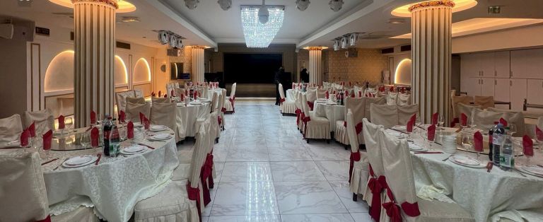 Dieses Bild zeigt einen eleganten, hell erleuchteten Bankettsaal oder ein gehobenes Restaurant, das sorgf&auml;ltig f&uuml;r eine gro&szlig;e Veranstaltung vorbereitet wurde.